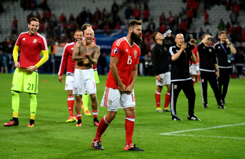 Photo of Wales players laughing at a large child whose daddy left him before showing him where the potty is via Getty